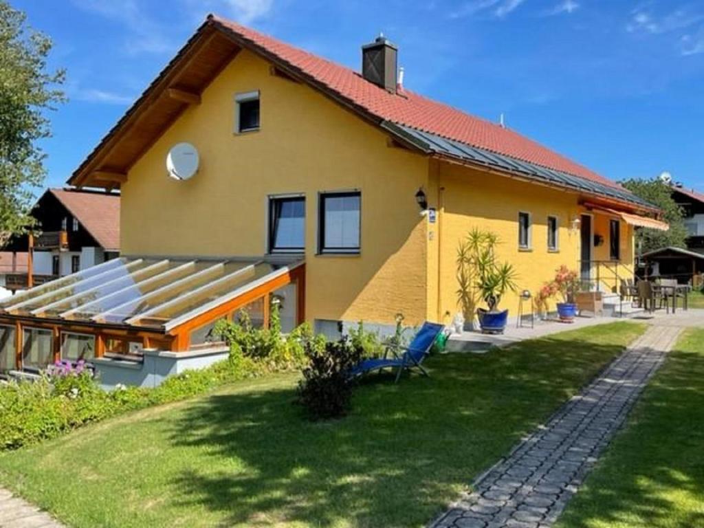 una casa amarilla con techo rojo en Haus Gertraud Schreiner, en Neuschönau
