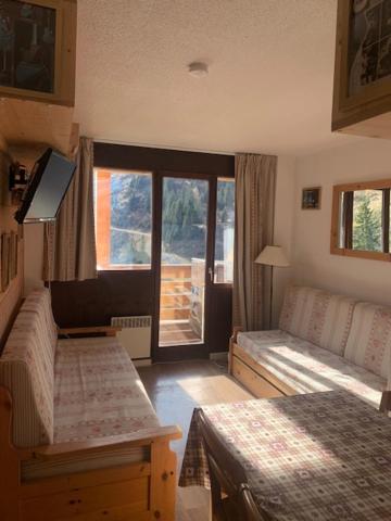 莫爾濟訥的住宿－Avoriaz le cedrat，一间卧室配有一张床、一张沙发和一个窗口