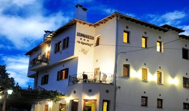 a large white building with its lights on at Hotel Erotas in Agios Dimitrios