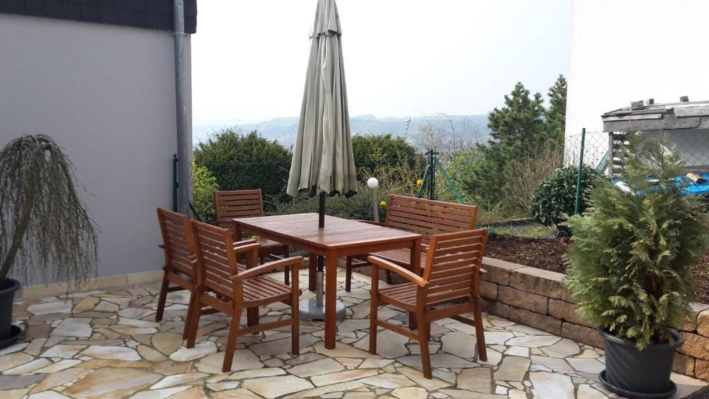 a table and chairs on a patio with an umbrella at Ferienwohnung Panorama in Konz