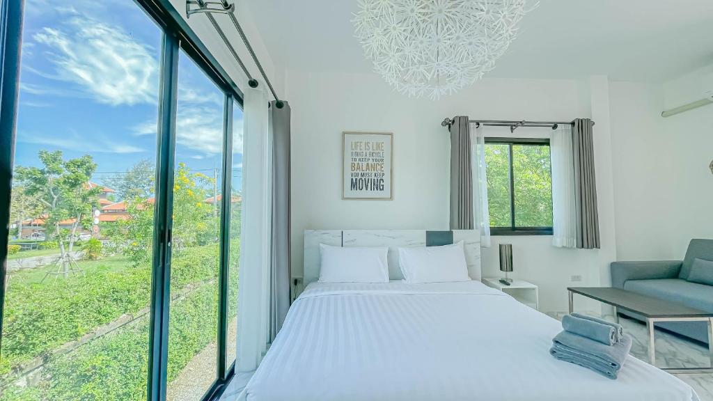 a bedroom with a bed and a large window at Z-Beach Resort in Ban Nong Ban Kao