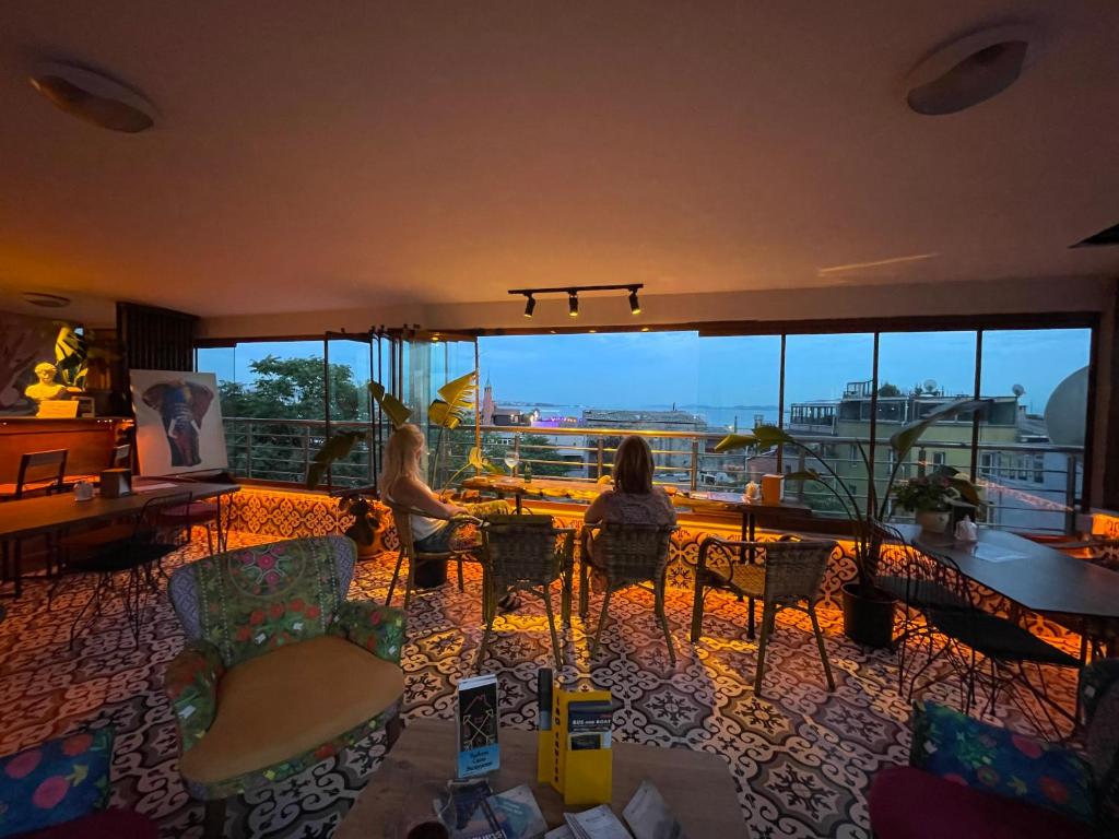 two people sitting in a room with a view of a city at The Local in Istanbul