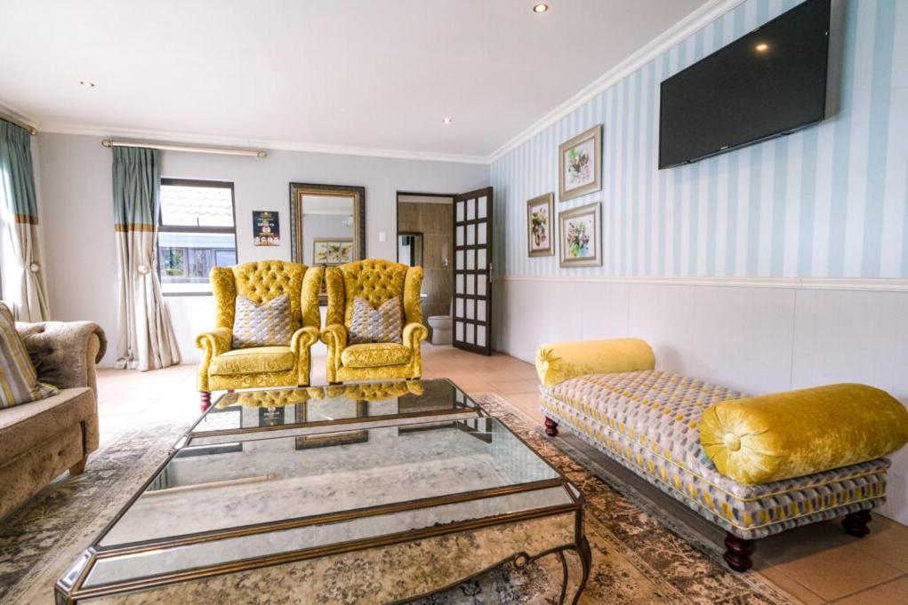 - un salon avec un canapé et une table dans l'établissement Casabella Guesthouse, à East London