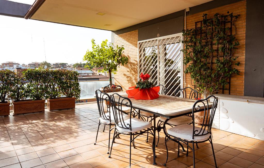 einen Tisch und Stühle auf einer Terrasse mit Balkon in der Unterkunft Quinto Piano in Rom