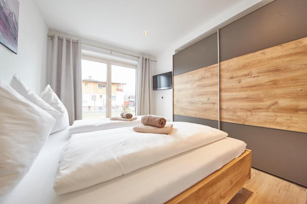 una camera da letto con due letti e una grande finestra di Appartement Atzingerberg a Maishofen