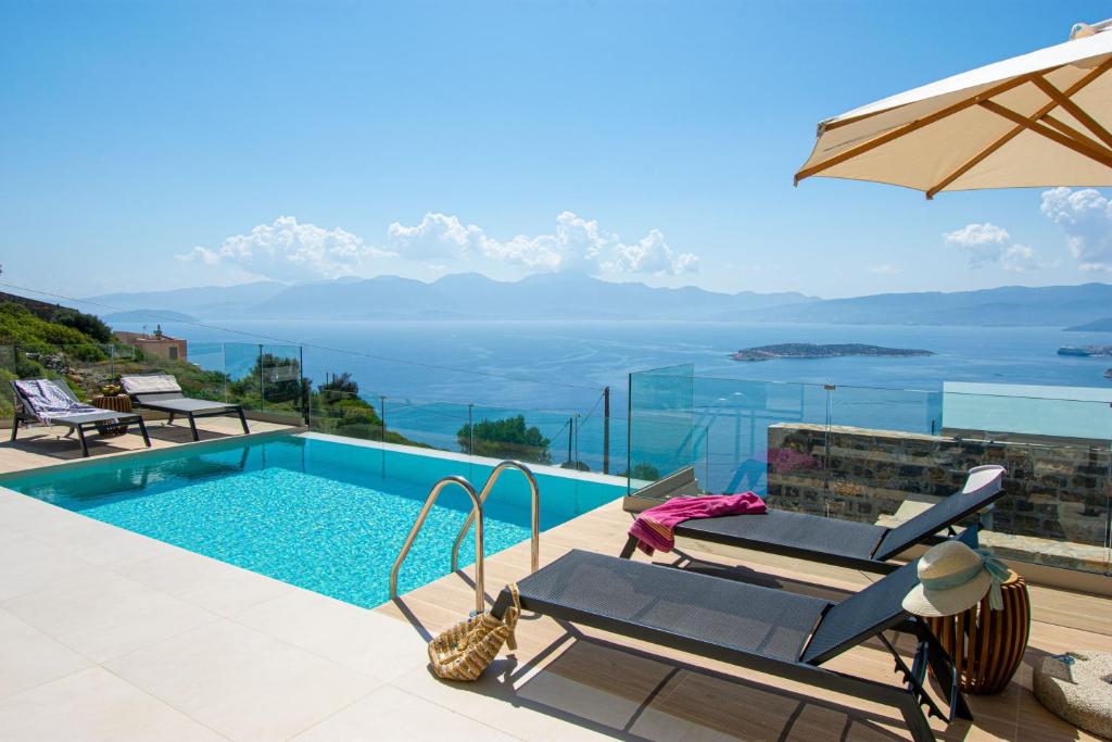 a villa with a swimming pool and a view of the ocean at Majestic View Villas in Agios Nikolaos