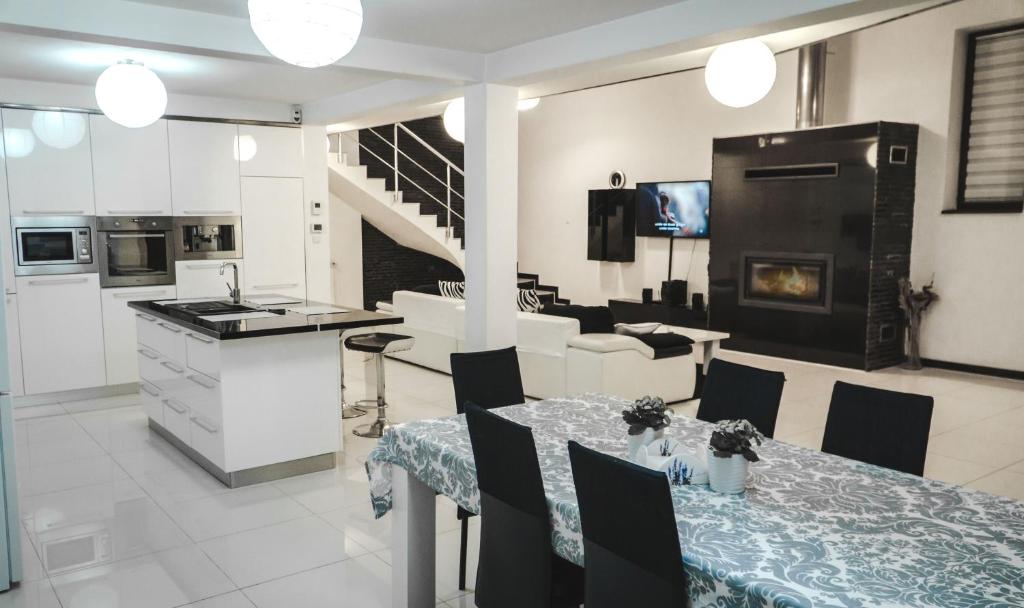 Vila Carolina Apulum في ألبا يوليا: مطبخ وغرفة معيشة مع طاولة ومطبخ وغرفة طعام