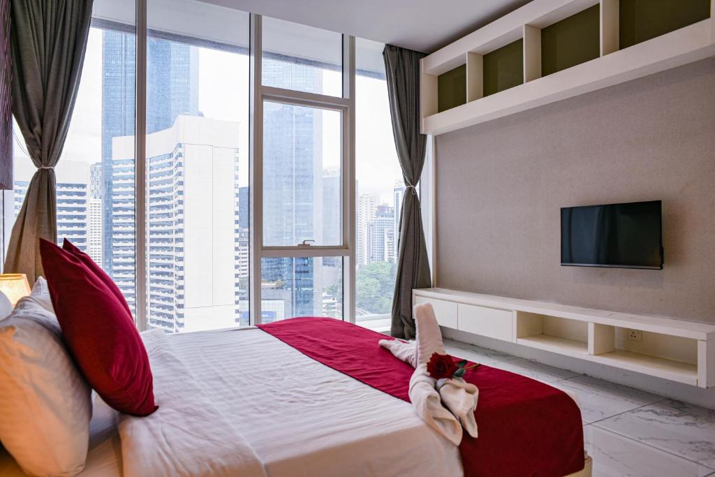 una camera d'albergo con un grande letto e una grande finestra di Happy Suite at Platinum KLCC a Kuala Lumpur