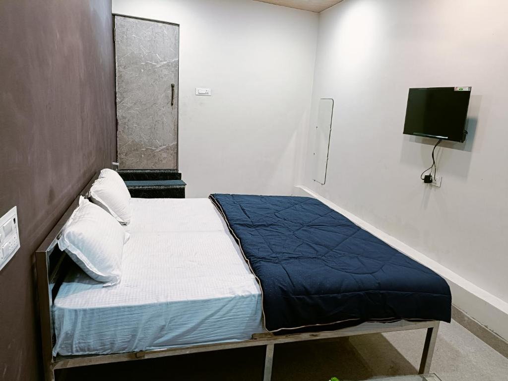 een klein bed in een kamer met een tv aan de muur bij HOTEL ROYAL INN in Satna