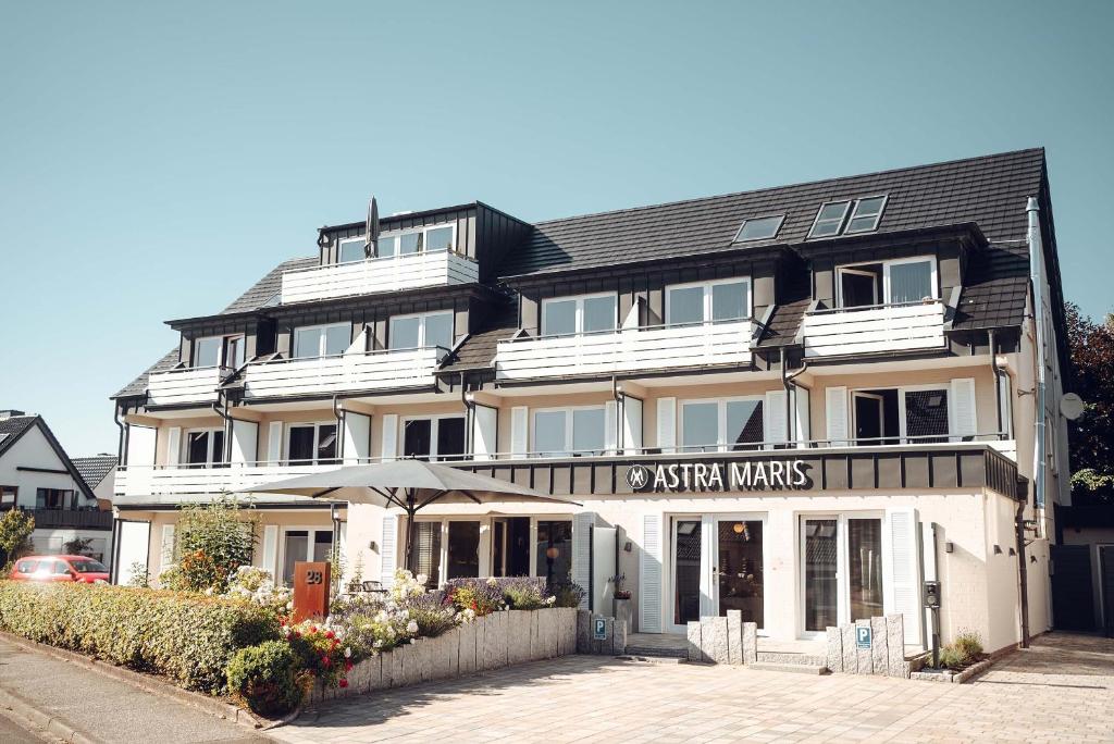- un grand bâtiment blanc avec un panneau dans l'établissement Hotel Astra Maris, à Büsum