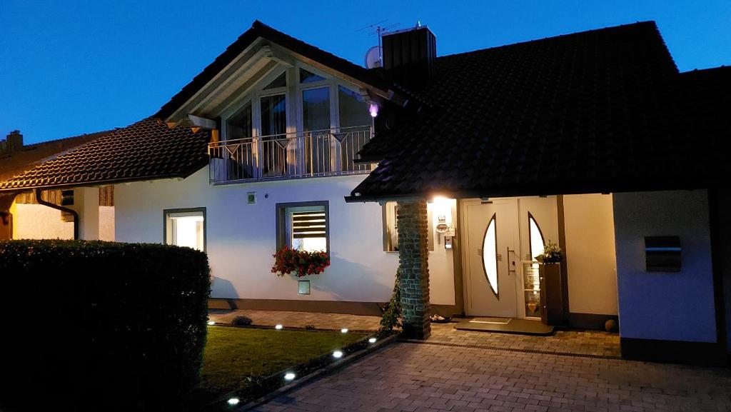 ein weißes Haus mit Balkon darüber in der Unterkunft Ferienwohnung Tina in Breitenberg