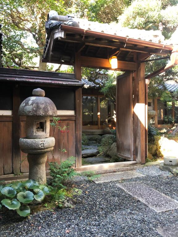 a japanese garden with a stone lantern and a building at Katsuemon in Gose