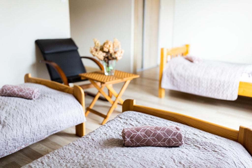 sypialnia z 2 łóżkami i stołem z krzesłem w obiekcie Rodzinny apartament FOLKER w mieście Cisiec