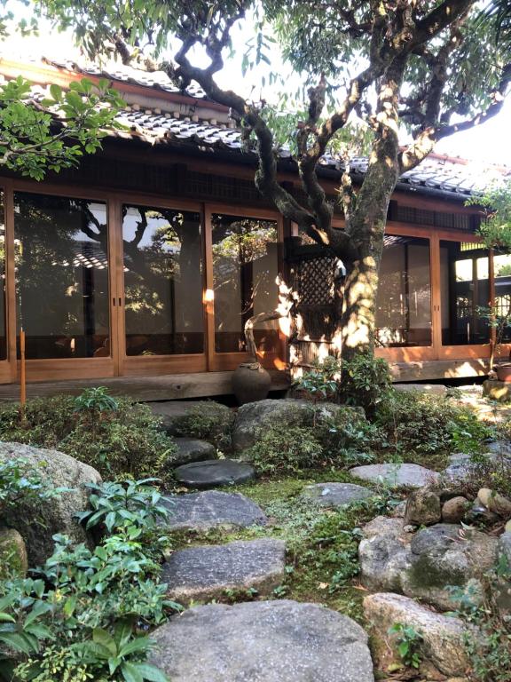 un giardino con rocce di fronte a un edificio di 一日一組限定 古民家の宿 勝右衛門 御所 a Gose