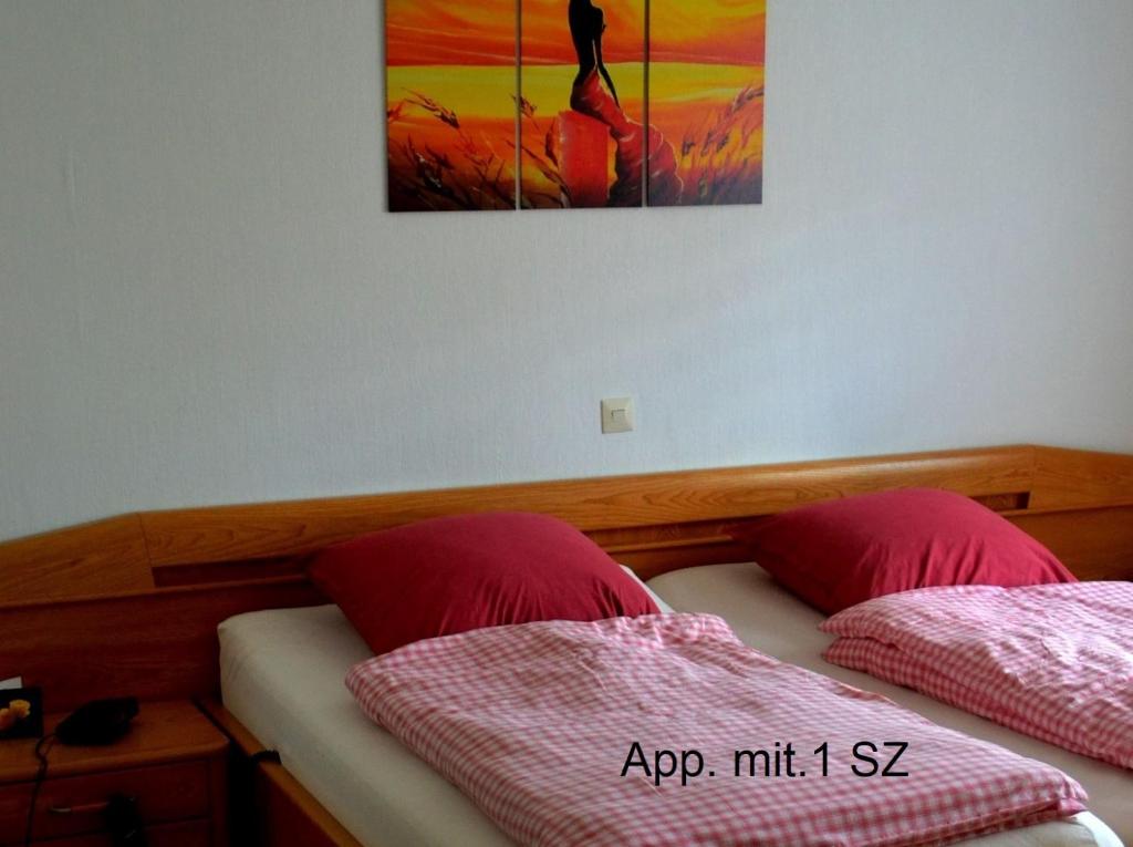 a bedroom with two beds and a painting on the wall at Frankenau Fewo Kellerwald in Frankenau