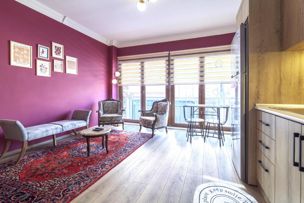 uma sala de estar com paredes roxas e uma mesa e cadeiras em Charming Flat near Kennedy Avenue in Fatih em Istambul