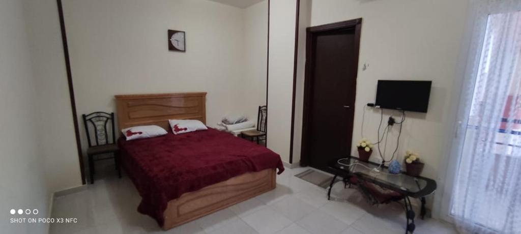 a bedroom with a bed and a desk and a television at Studio Apartment at Tiba Star in Hurghada