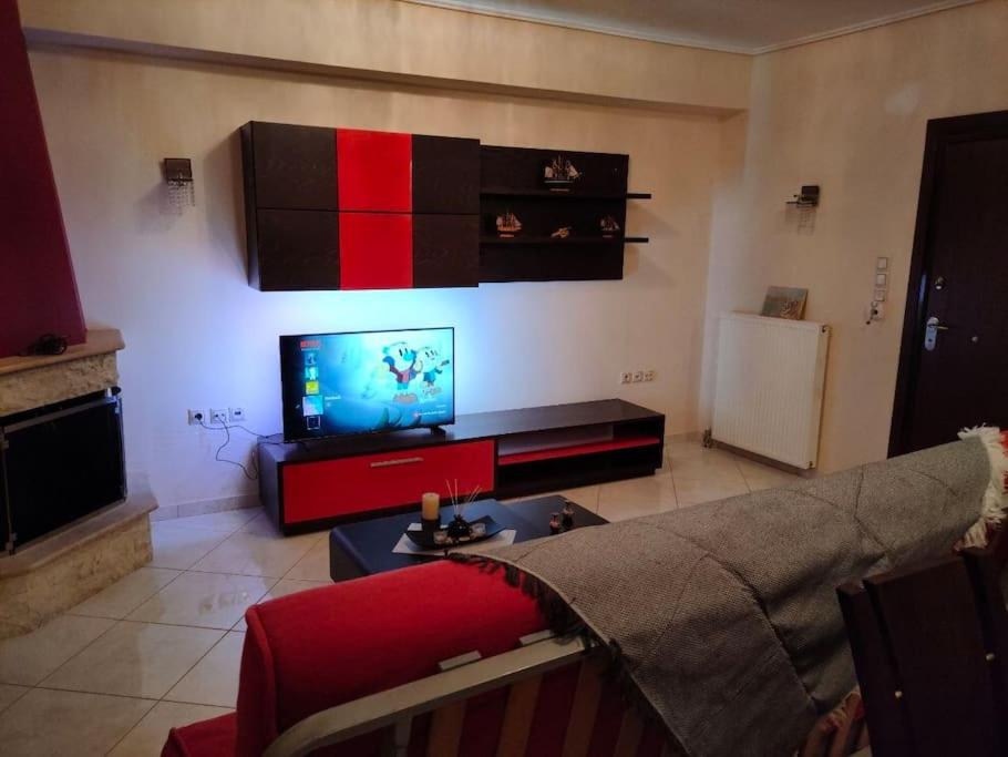 ein Wohnzimmer mit einem Sofa und einem Flachbild-TV in der Unterkunft Το σπίτι της Περσεφόνης in Athen