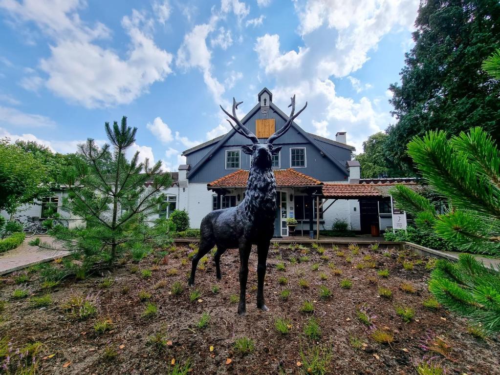 a statue of a giraffe in front of a house at Veluwe Hotel de Beyaerd in Hulshorst