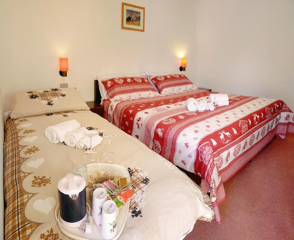 a room with two beds and a table with towels at Cèsa Cherpei - Dog Friendly in Campitello di Fassa