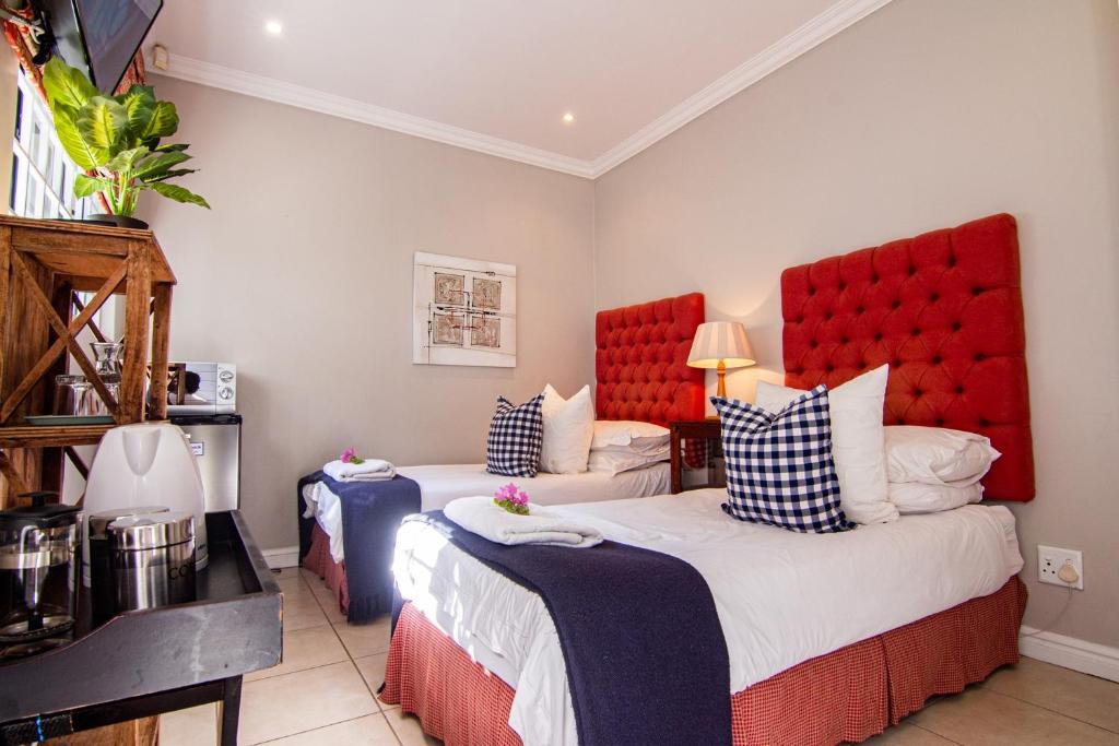 Un dormitorio con dos camas con cabeceros rojos. en 25A Oyster, en Durban