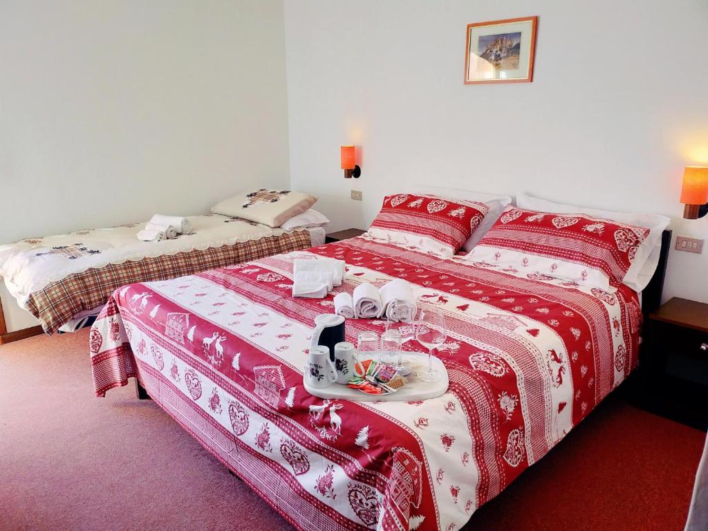a hotel room with two beds with red and white blankets at Cèsa Cherpei - Dog Friendly in Campitello di Fassa