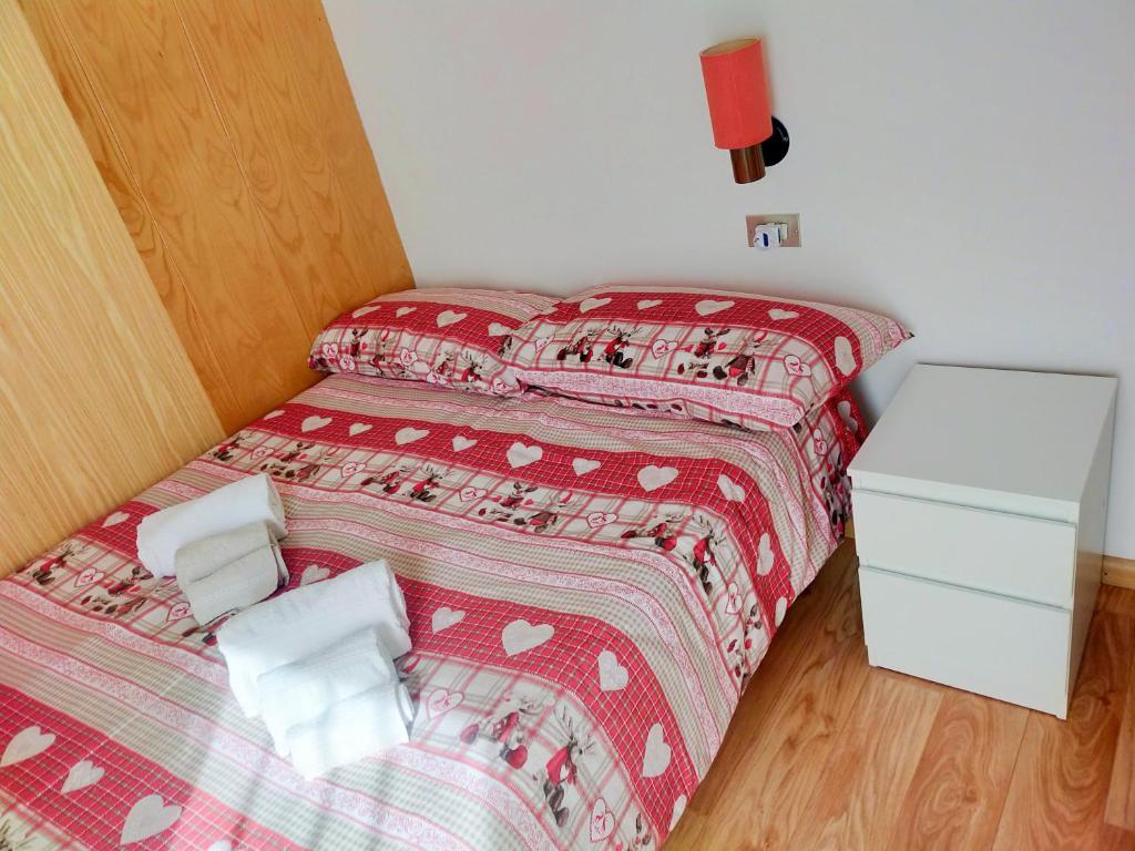 a small bedroom with two beds with red sheets at Cèsa Cherpei - Dog Friendly in Campitello di Fassa