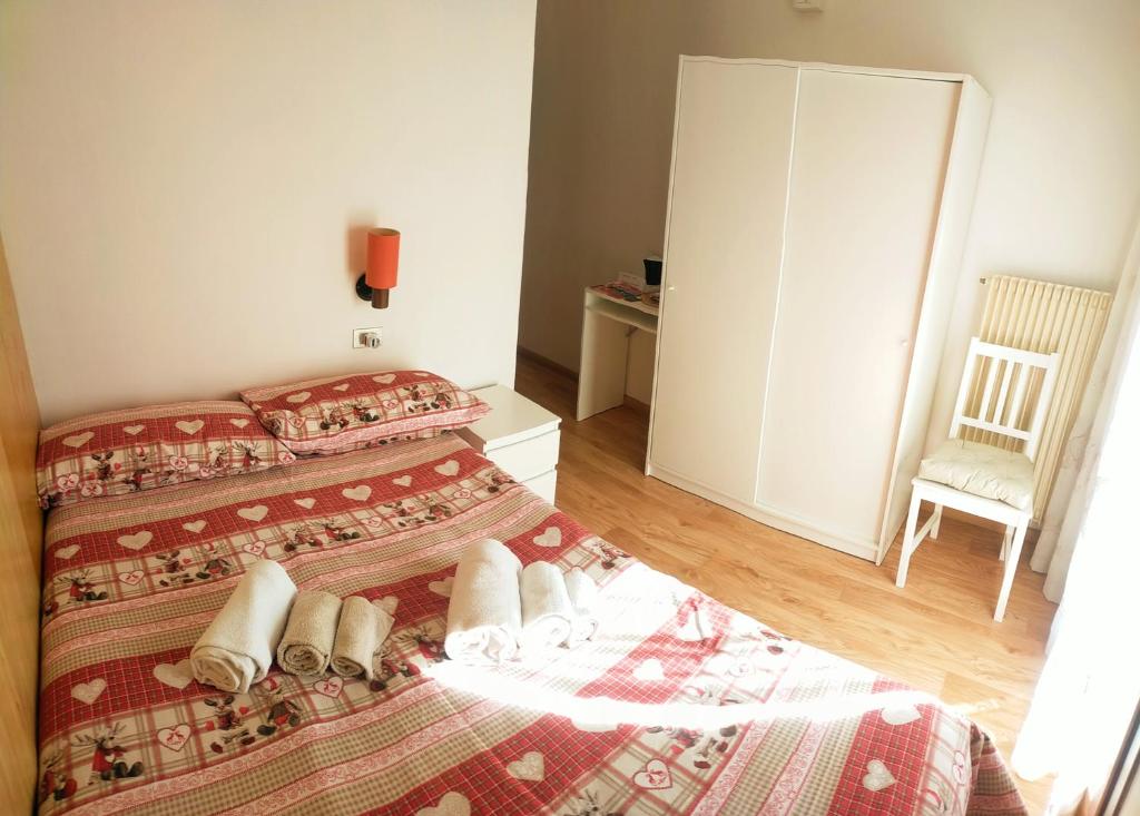 a hotel room with two beds and a chair at Cèsa Cherpei - Dog Friendly in Campitello di Fassa