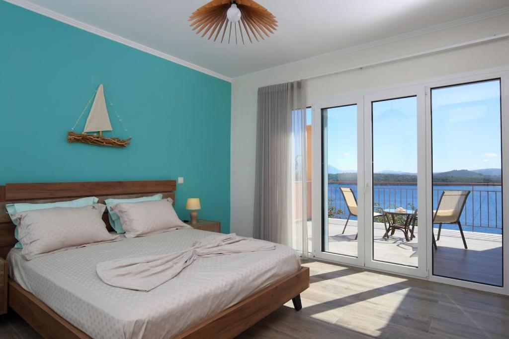 a bedroom with a bed and a view of the ocean at Villa Melias, luxurious villa with superb view of the islands, 400 m from the sea in Nydri