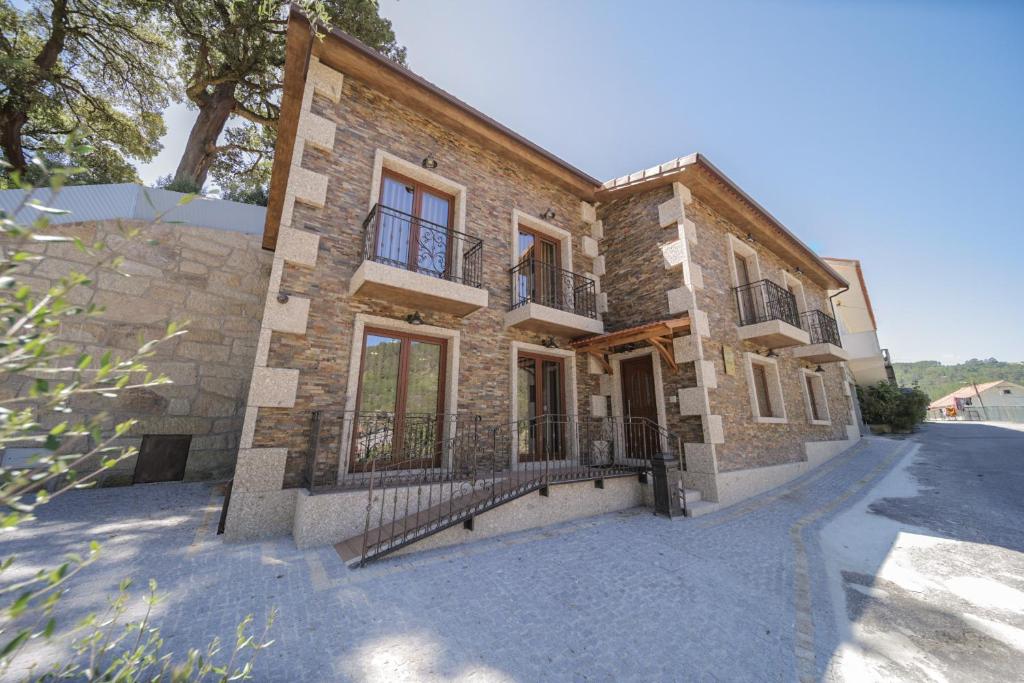 een oud stenen huis met een poort op een straat bij Casa da Fonte - Gerês in Geres