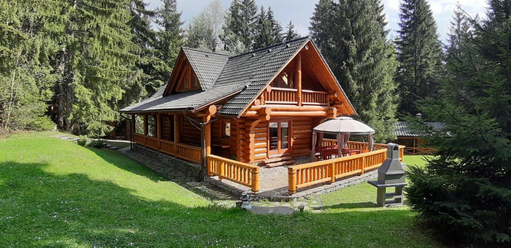 a large wooden cabin in a forest with trees at Chata Marína a Matej Kubínska hoľa in Dolný Kubín