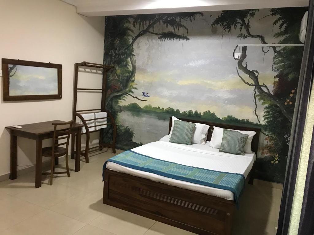 モラトゥワにあるAmani Lake Resortのベッドルーム1室(ベッド1台付)が備わります。壁には絵画が飾られています。