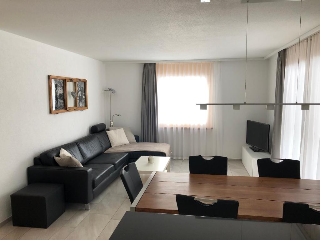 ein Wohnzimmer mit einem Sofa und einem Tisch in der Unterkunft Seebach B1 in Arosa