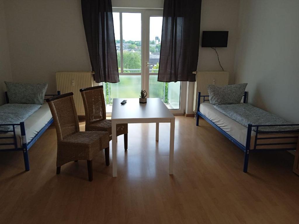 a living room with a table and chairs and a window at Apartments K11 für Monteure in Chemnitz in Chemnitz