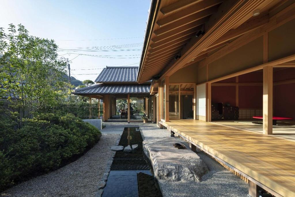 Casa moderna con porche de madera largo en 萌蘖　露天風呂とサウナがある現代の湯治場, en Kagoshima