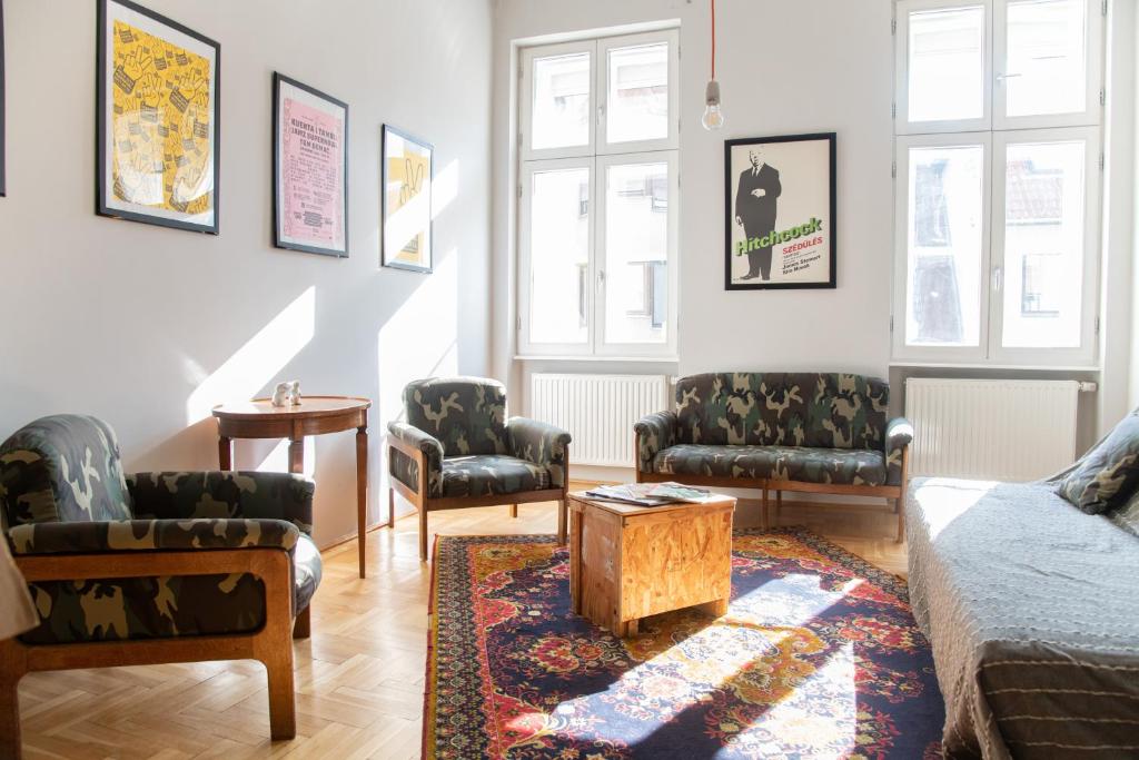 ein Wohnzimmer mit einem Sofa, Stühlen und einem Tisch in der Unterkunft Stylishly redecorated apartment in great location in Budapest
