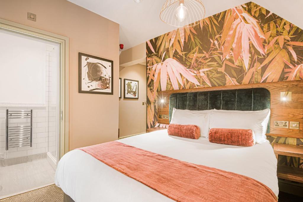 a bedroom with a large bed with a flower mural on the wall at The King's Arms by Innkeeper's Collection in Knowle