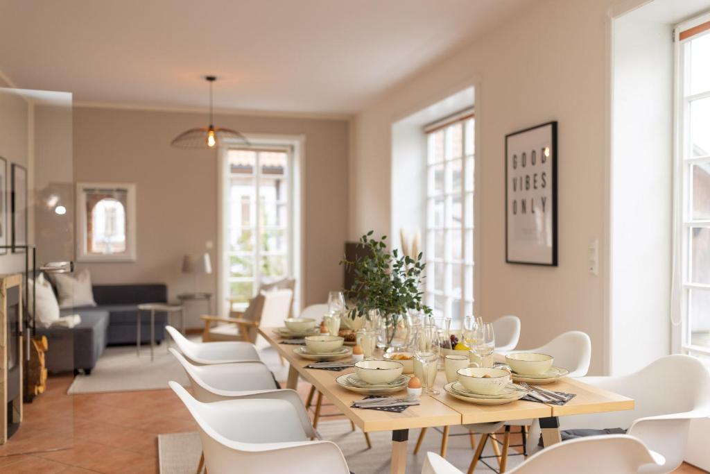 a dining room with a table and white chairs at ErholungNOW in Bispingen