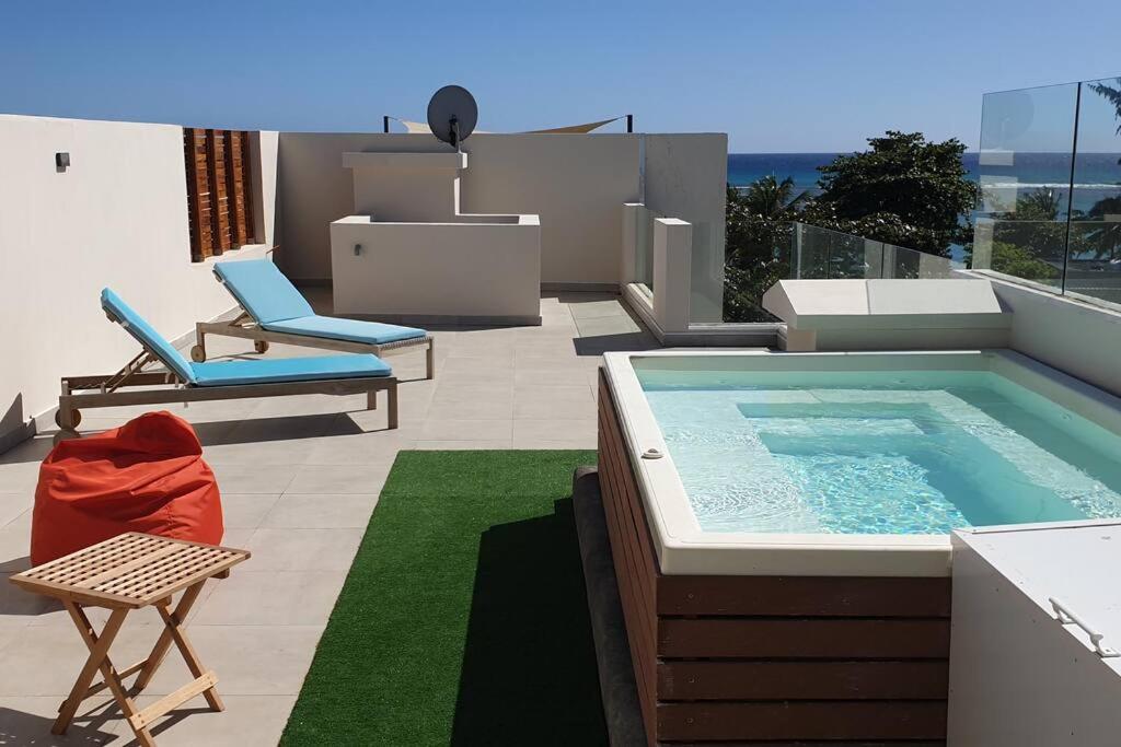 a backyard with a swimming pool and a patio with chairs at Penthouse vue sur mer 200m2 in Pereybere
