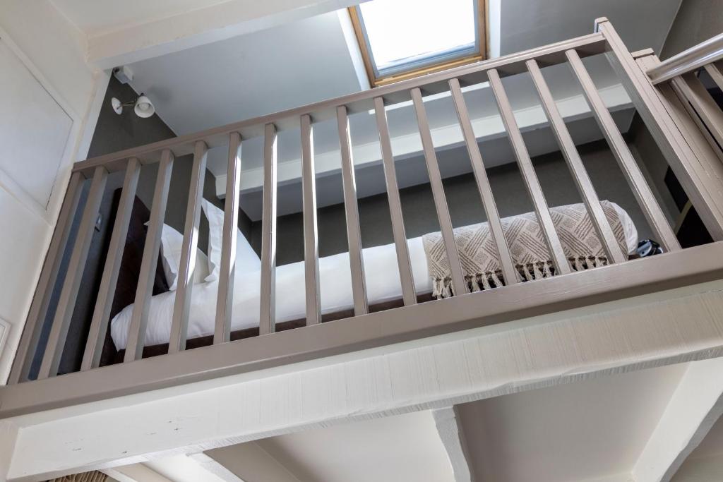 a loft bed in a room with a crib at Hôtel Madeleine Haussmann in Paris