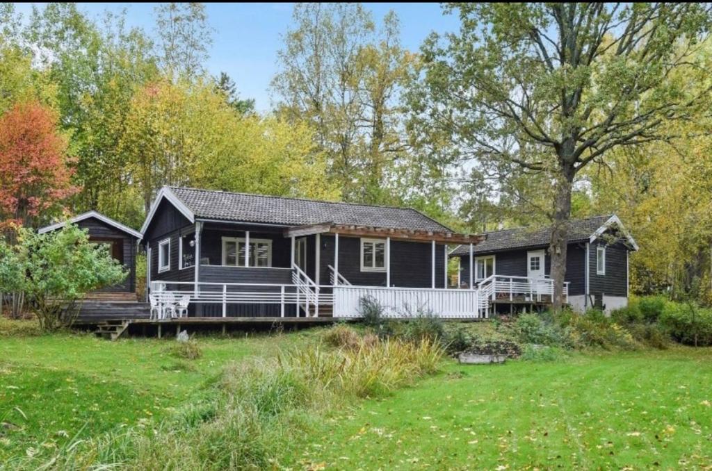 una casa nera con portico e cortile di Cosy house in the archipelago a Värmdö