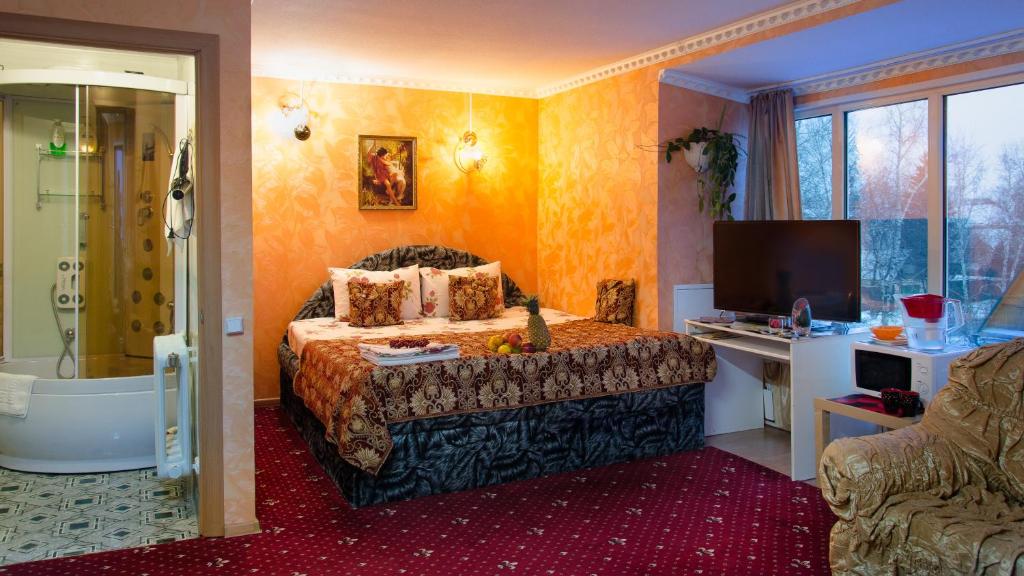 a bedroom with a bed and a tub and a television at Guest House Vostryakovo in Domodedovo