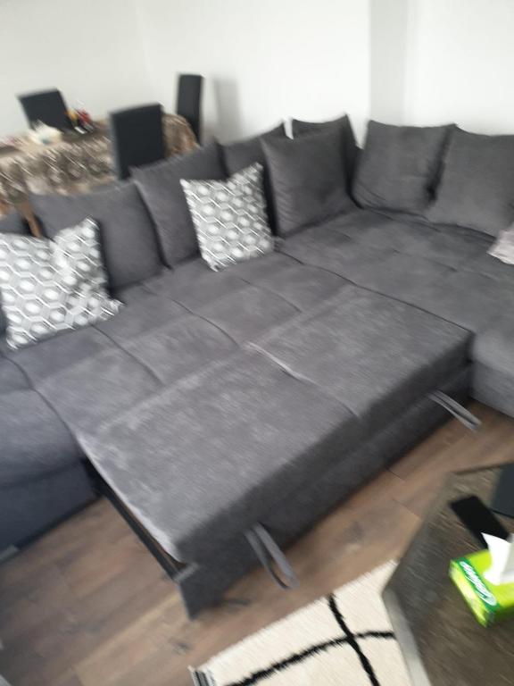 1 sofá grande en la sala de estar en LOVE Appartement partagé avec le proprietaire, en Saint-Louis