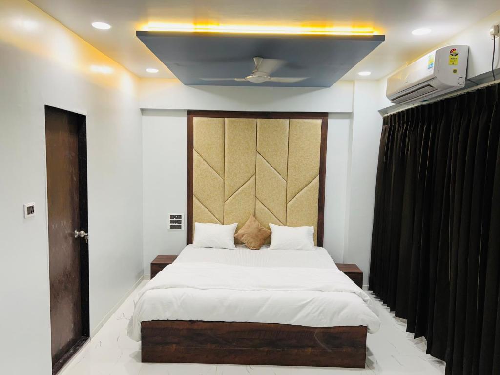 een slaapkamer met een groot bed met witte lakens bij Hotel New City Light in Surat