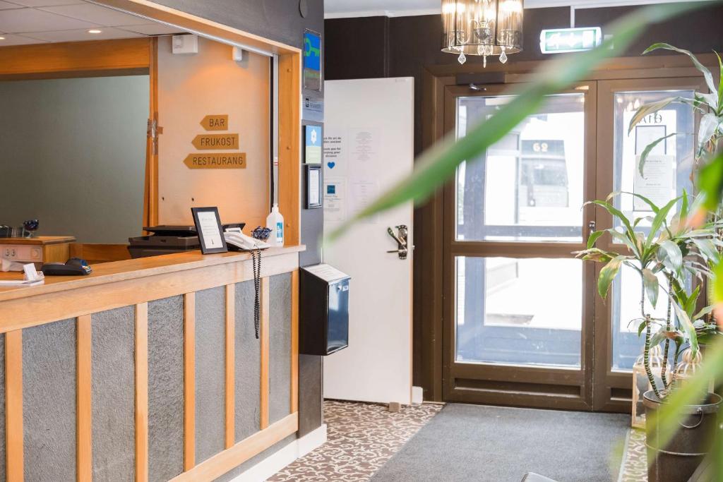 a lobby with a reception desk and a door at Sure Hotel by Best Western Algen in Östersund