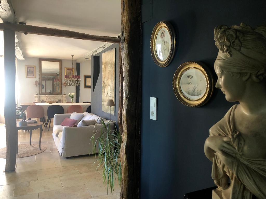 a living room with clocks on the wall and a statue at Val du Lys in Sainte-Maure-de-Peyriac