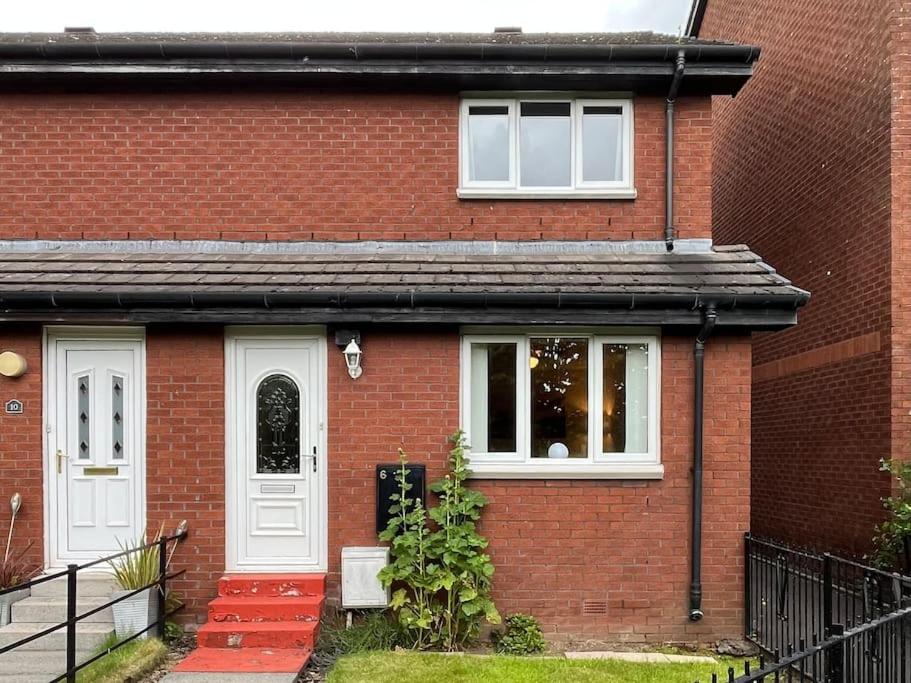 una casa de ladrillo rojo con puerta blanca en Spacious home near Glasgow Green, en Glasgow