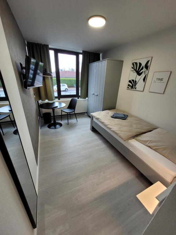 1 dormitorio con cama, escritorio y mesa en Guesthouse WI rooms, en Julich