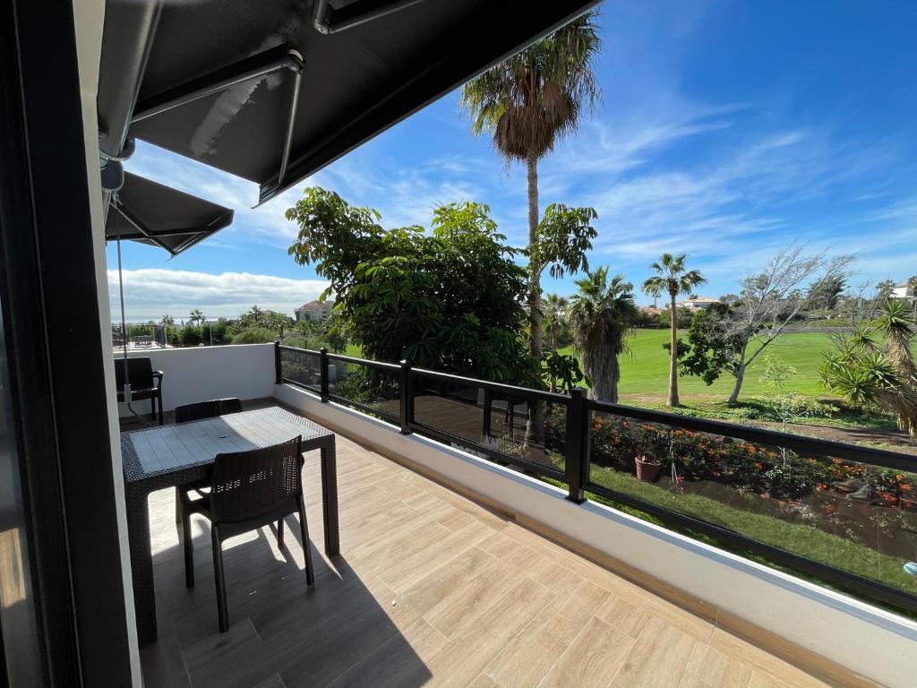 a balcony with a table and a view of a golf course at Residencial Bitacora in San Miguel de Abona