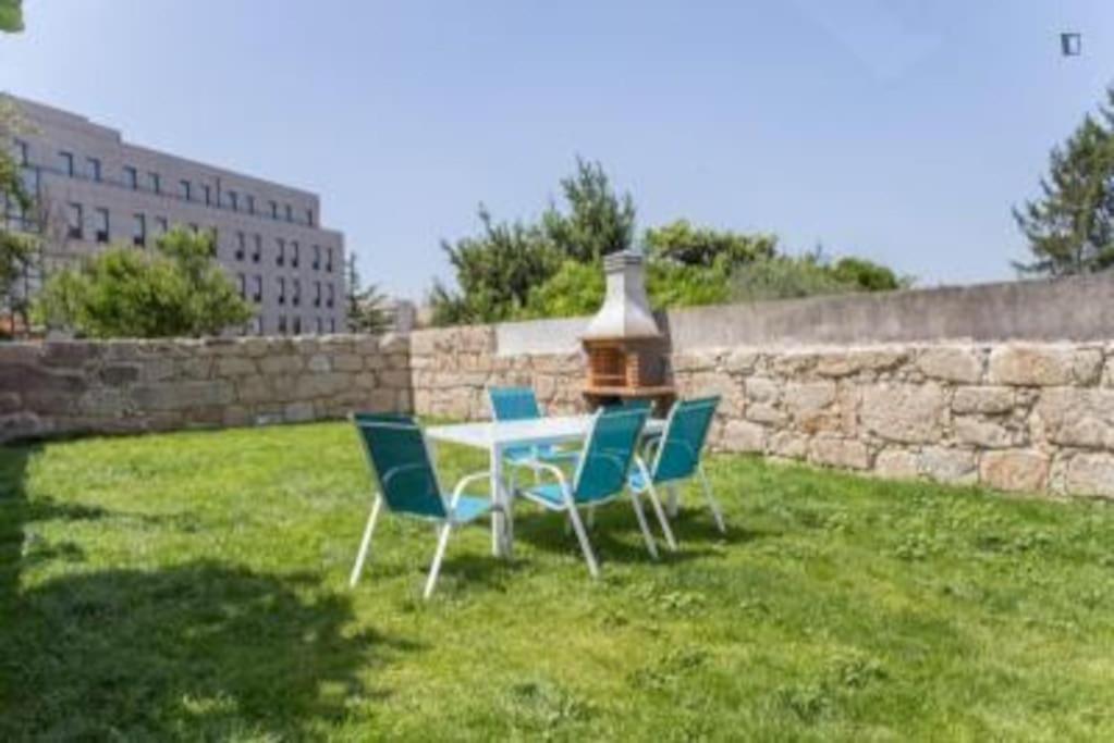 une table et des chaises dans une cour à côté d'un mur dans l'établissement OPO - Fantastic studio with garden, à Porto